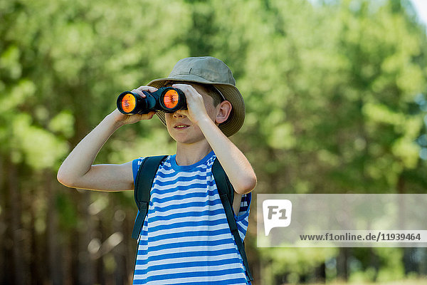 Boy looking through binoculars outdoors