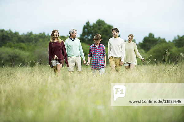 Family walking together in field of tall grass
