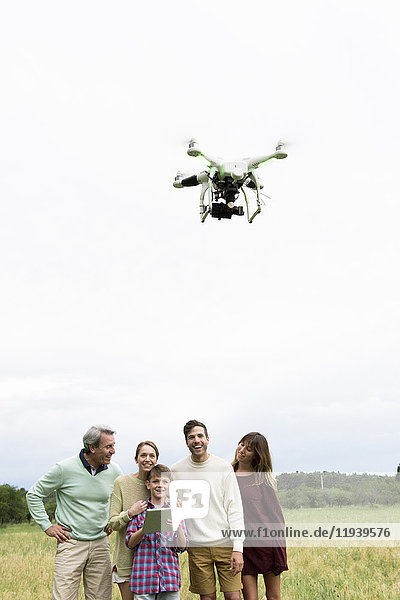 Familie spielt mit Drohne im Feld