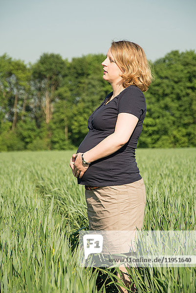 Schwangere Frau auf einem Feld