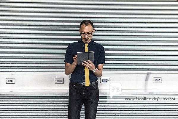 Businessman in city using touchscreen on digital tablet