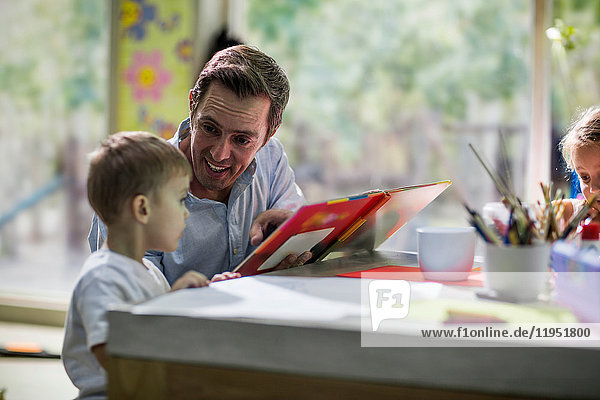 Teacher looking at book with child