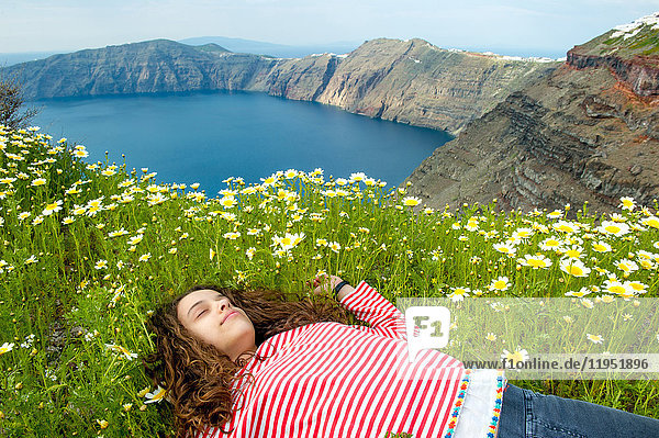 Mädchen schläft auf einem Blumenbeet  Oía  Santorini  Kikladhes  Griechenland