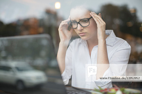 Woman using laptop looking stressed