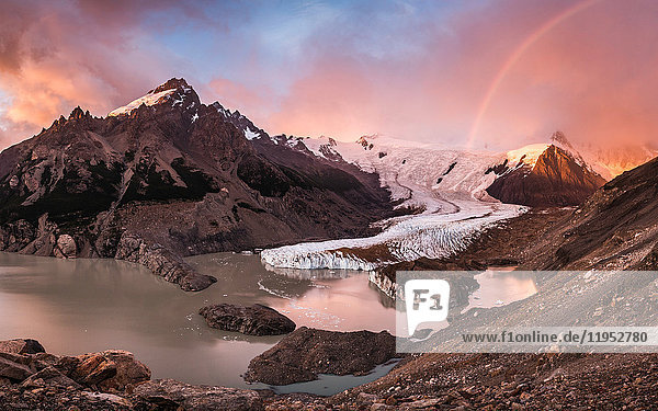 Regenbogen und dramatischer rosa Himmel über dem Torre-Gletscher und der Lagune im Los Glaciares-Nationalpark  Patagonien  Argentinien