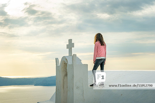 Mädchen oben auf der Kirche stehend  Oía  Santorini  Kikladhes  Griechenland