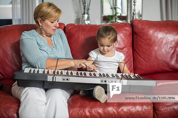 Girl and grandmother playing keyboard
