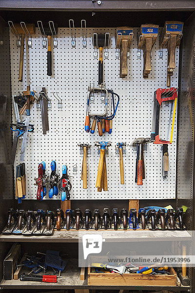 Werkbank in der Werkstatt eines Bootsbauers  Auswahl von Handwerkzeugen für die Holzbearbeitung  die an einer Wand hängen.
