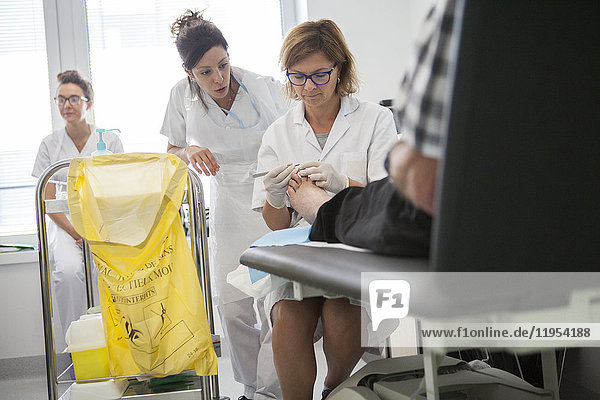 Reportage über die Fußsprechstunde für Diabetiker in einem Krankenhaus in Savoyen  Frankreich. Diese Sprechstunden werden von einem spezialisierten Team durchgeführt und sind der Behandlung und Nachsorge von Fußverletzungen bei Diabetikern gewidmet. Die Krankenschwester und der Fußpfleger führen die Behandlung durch.