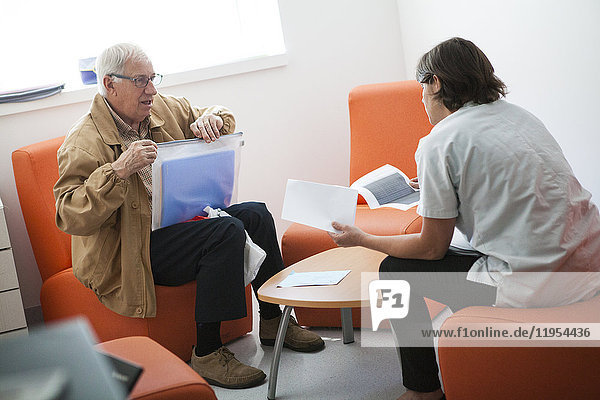Reportage on the cancer diagnosis centre in an oncology service. The Savoie multidiscipline information and oncology meeting space (ERMIOS) is a privileged space in which different professionals who specialize in oncology support care  work. A nurse receives a patient for an interview following his cancer diagnosis. She informs him about his illness  treatment and follow-up care at the hospital.