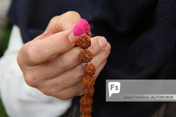 Devotee holding hindu prayer beads. Gretz. France.