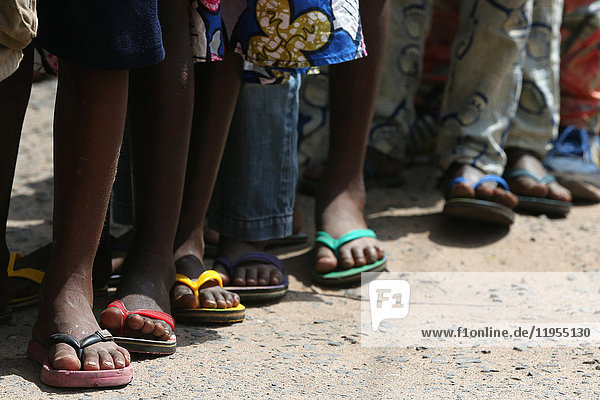 Grundschule in Afrika. Schulkinder tragen bordeauxfarbene Flip-Flops. Lome. Togo.