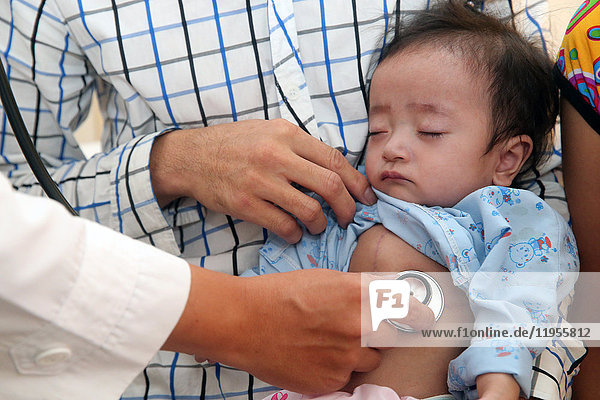 Tam Duc Heart Hospital. Ein Arzt hört das Herz eines jungen Mädchens ab. Ho-Chi-Minh-Stadt. Vietnam.