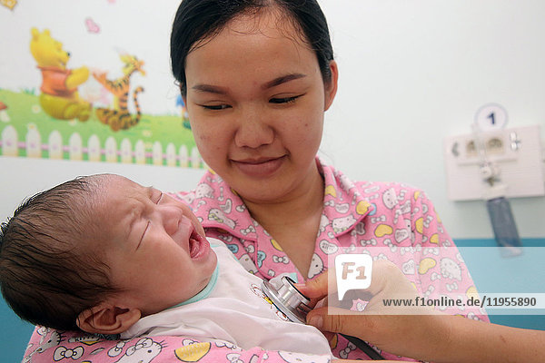 Das Herzinstitut bietet vietnamesischen Patienten  die an Herzkrankheiten leiden  eine hochwertige Versorgung. Ein Arzt hört das Herz eines kleinen Babys ab. Ho-Chi-Minh-Stadt. Vietnam.