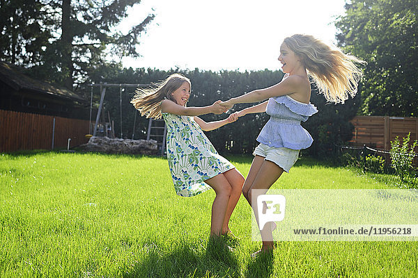 Two happy playful girls in garden