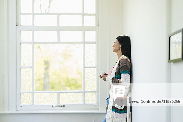 Woman at home looking out of window