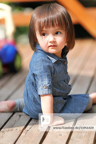 Mixed-race young girl playing on wooden deck