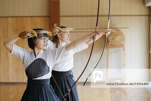 Multi-ethnic traditional Kyudo Japanese archery athletes practicing