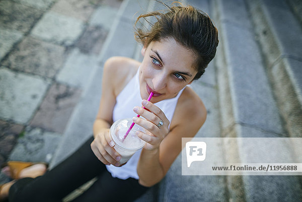 Portrait of young woman drinking a smoothie