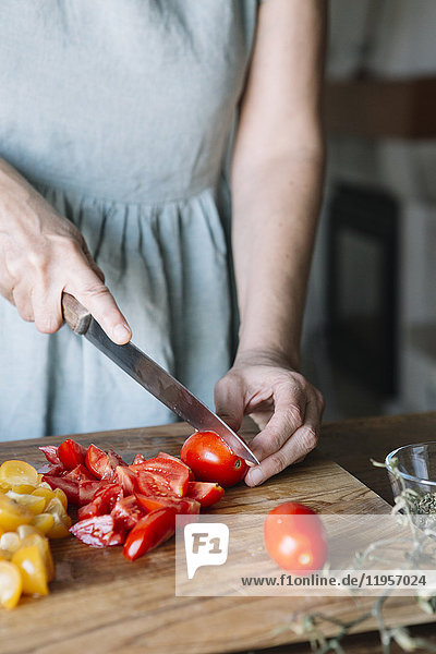 Nahaufnahme einer Frau beim Schneiden von frischen Tomaten