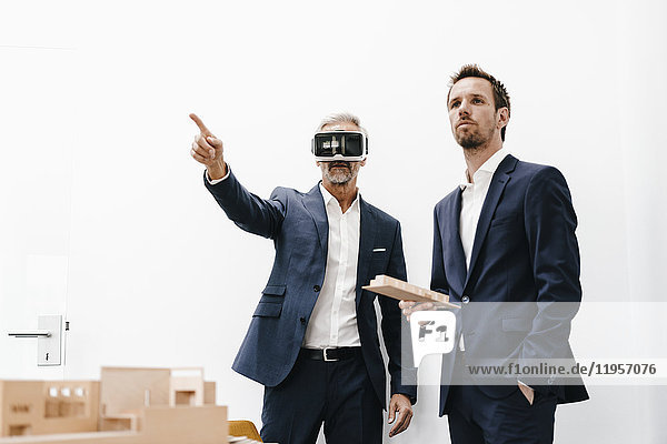 Two businessmen with VR glasses and architectural model