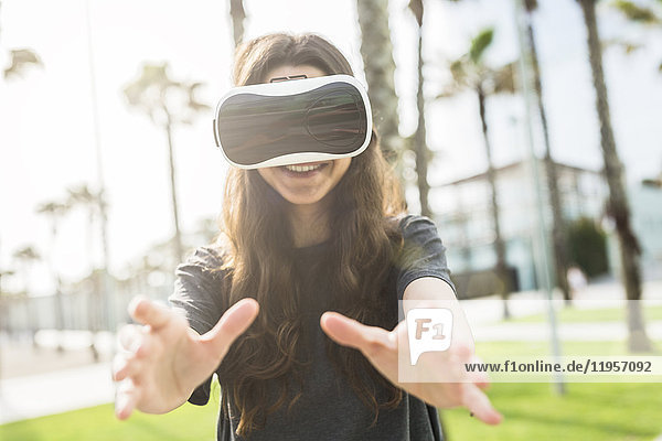 Young woman wearing VR glasses outdoors