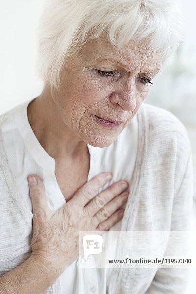 MODELL FREIGEGEBEN. Ältere Frau berührt Brust.