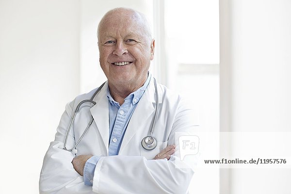 MODEL RELEASED. Senior male doctor smiling towards camera.