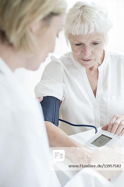 MODELL FREIGEGEBEN. Ältere Frau lässt sich den Blutdruck messen.