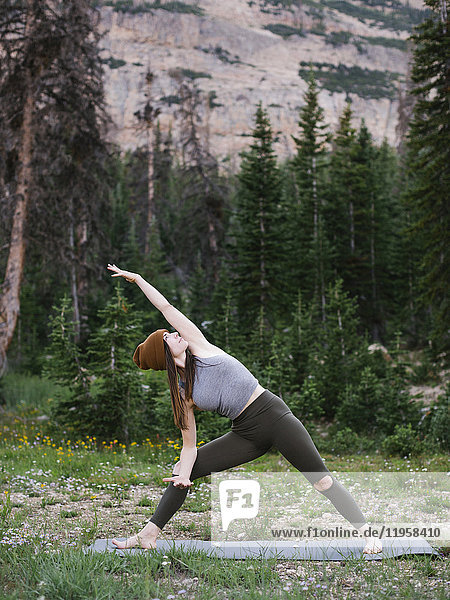 Frau übt Yoga im Wald