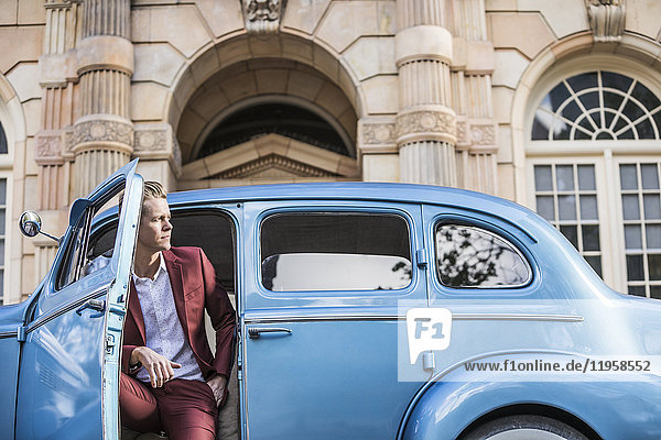 Elegant man sitting in vintage car
