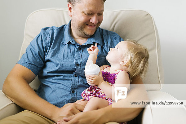 Vater füttert kleines Mädchen (12-17 Monate)