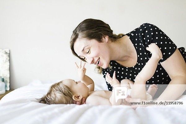 Baby Mädchen (6-11 Monate) spielt mit Mutter