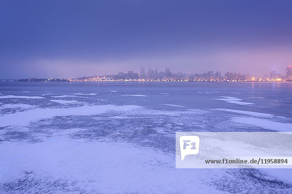Ukraine  Gebiet Dnepropetrowsk  Stadt Dnepropetrowsk  Dramatischer Himmel über zugefrorenem Fluss in der Abenddämmerung