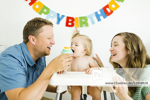 Mutter und Vater feiern den ersten Geburtstag ihrer Tochter (12-17 Monate)