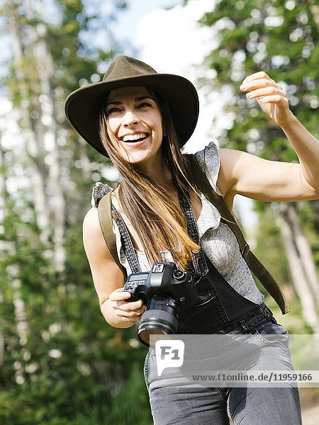 Woman with camera hiking in forest