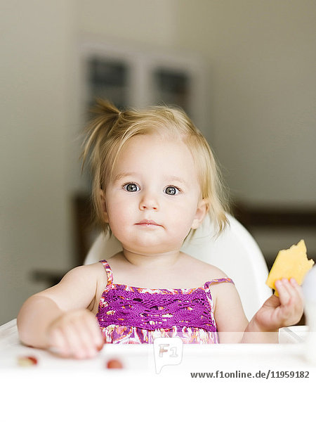 Porträt eines kleinen Mädchens (12-17 Monate) beim Mittagessen