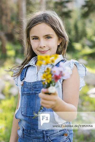 Porträt eines Mädchens (8-9) mit Wildblumen in der Hand