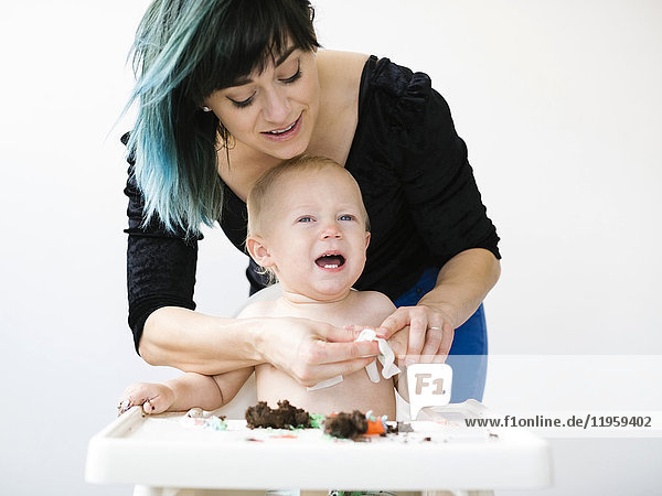 Mutter reinigt Baby (12-17 Monate) von Cupcake