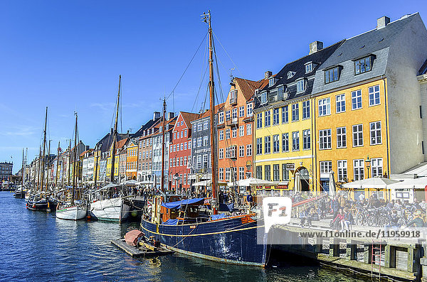 Nyhavn  das Hafenviertel aus dem 17. Jahrhundert mit einer Reihe farbenfroher historischer Gebäude  Promenade und festgemachten Segelschiffen in Kopenhagen  Dänemark.