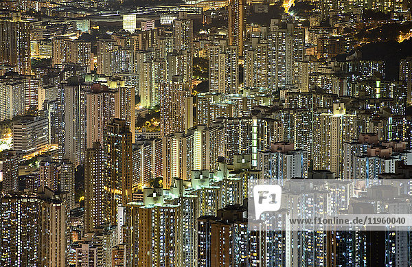 Luftaufnahme von beleuchteten Wolkenkratzern in Hongkong bei Nacht.