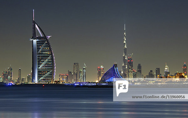 Stadtbild von Dubai  Vereinigte Arabische Emirate in der Abenddämmerung  mit den beleuchteten Wolkenkratzern Burj Khalifa und Burj Al Arab  die das Hafenviertel säumen.