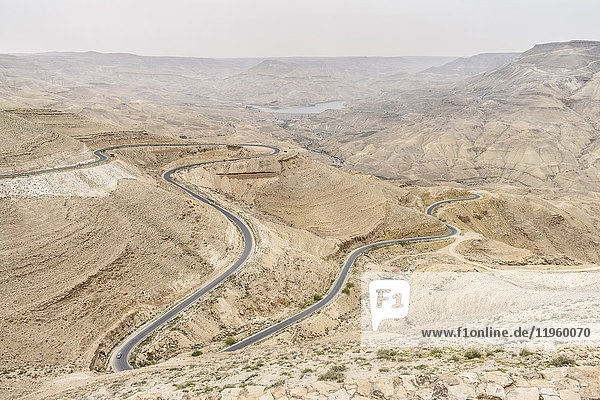 Luftaufnahme einer Landstraße  die sich durch die jordanische Wüstenwüste schlängelt  Jordanien.