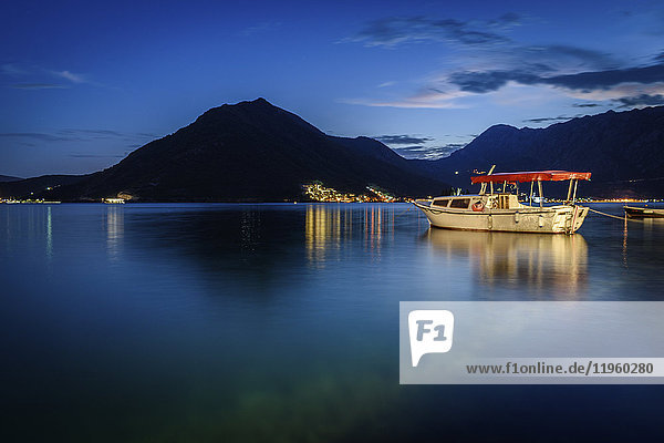 Boot vertäut im Hafen von Perast in der Bucht von Kotor  Montenegro bei Nacht  Berg in der Ferne.