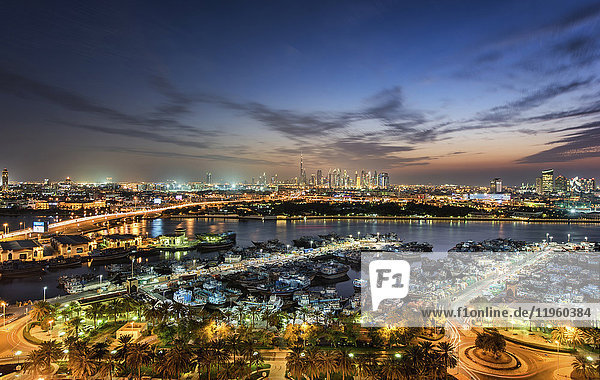 Stadtlandschaft mit beleuchteten Wolkenkratzern und Yachthafen in Dubai  Vereinigte Arabische Emirate in der Abenddämmerung.