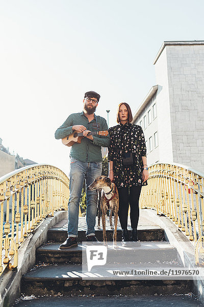 Porträt eines coolen Paares mit Hund auf dem Steg stehend