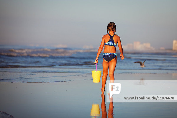Rückansicht eines Mädchens am Strand  das einen Eimer hält  North Myrtle Beach  South Carolina  Vereinigte Staaten  Nordamerika