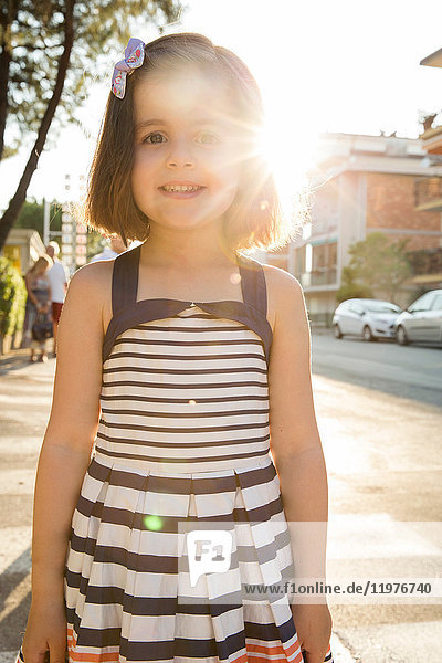 Porträt eines Mädchens auf der Straße  das lächelnd in die Kamera schaut