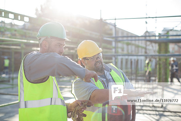 Construction workers in discussion on building site