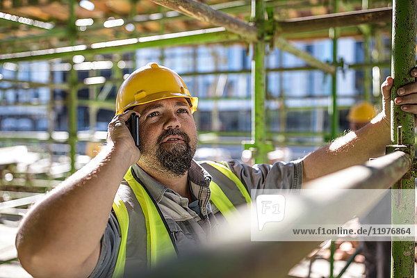 Construction worker using mobile phone